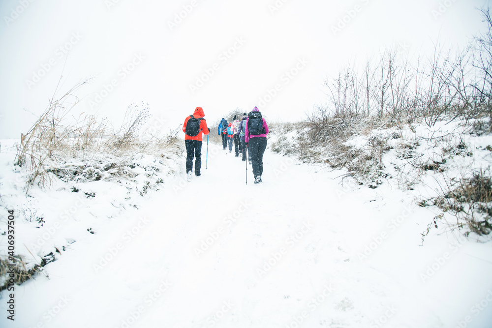 Group of hikers walking on the hike trail on snow winter day. Group of hikers walking on the hike trail on snow winter day.