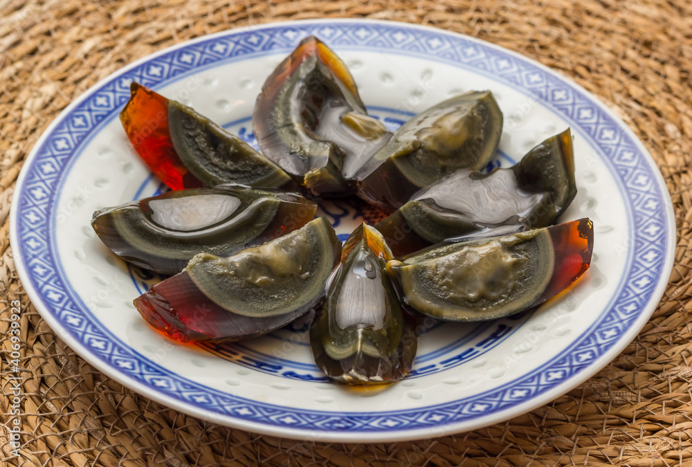 Black century eggs cut in parts on a chinese plate