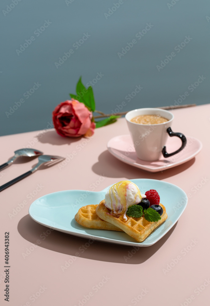 Heart shaped belgian waffles on blue plate and cup of coffee on pink background. Happy Valentine's Day. Heart shaped belgian waffles on blue plate and cup of coffee on pink background. Happy Valentine's Day.