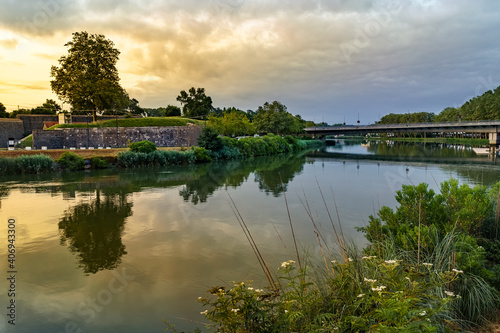 Green landscape with reflections on the Bayonne River in France. 