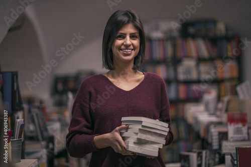 Portrait of beautiful woman bookshop owner. Successful independent businesswoman, owner of a book shop