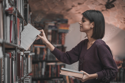Portrait of beautiful woman bookshop owner. Successful independent businesswoman, owner of a book shop