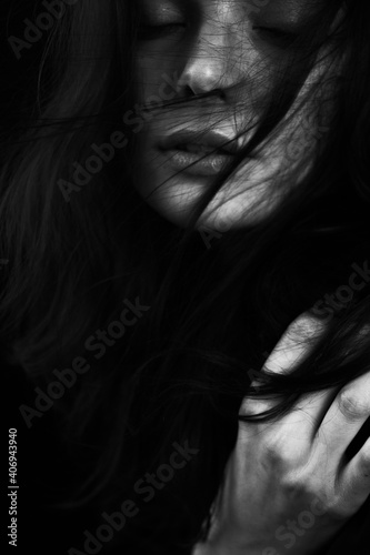Fototapeta Naklejka Na Ścianę i Meble -  Emotional Sensual black and white portrait of a beautiful girl on a dark background