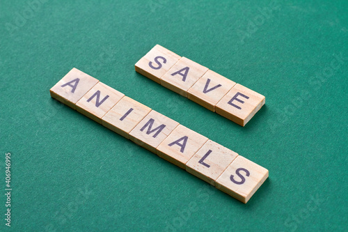 Save animals concept. Words made of wooden blocks isolated on green background. photo