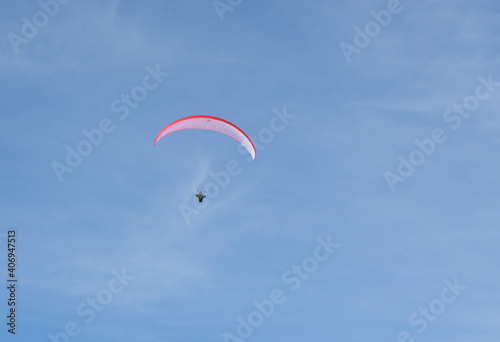 Paraglider flying over the mountains in winter