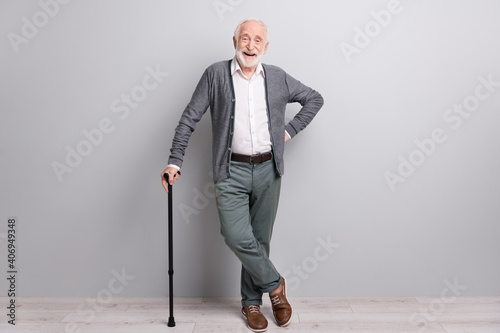 Full size photo of hooray old man stand laugh with wand wear dark sweater trousers isolated on grey wall photo