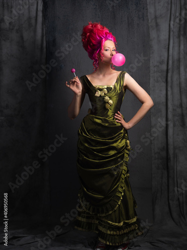 Neo kitsch, young woman in Baroque style, costume and high hairstyle in historical style and modern elements. Pink hair and a bubble of pink gum, Funny contrast of old and modern, portrait photo