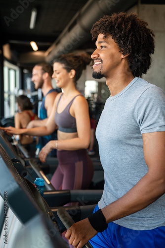 Group of young people running on treadmills in sport gym