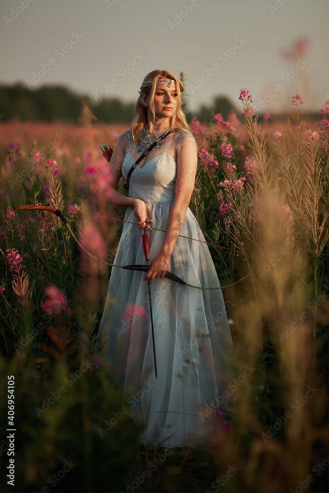 Obraz premium A girl in a dress shoots a bow. Weapon bow. Bow and arrows. Archery. Archery on the field