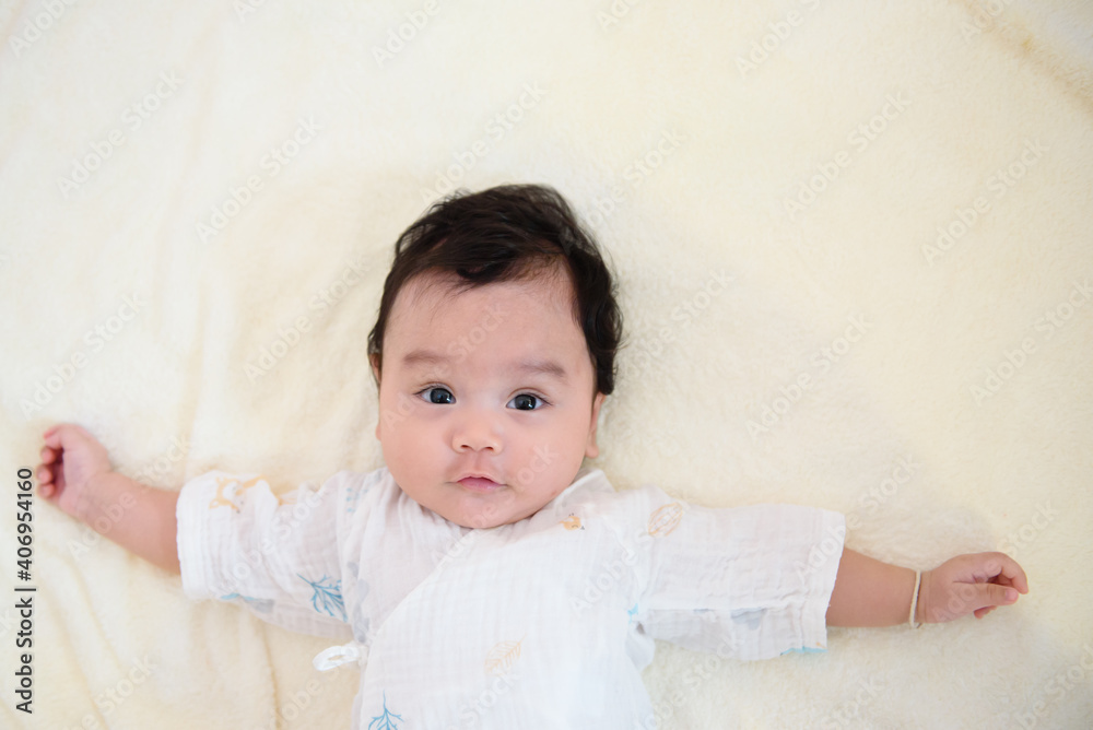 Top view of cute little Asian baby cheerful and looking at the camera with copy space Top view of cute little Asian baby cheerful and looking at the camera with copy space