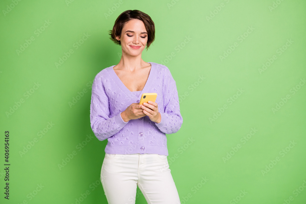 Photo of charming positive person look phone typing blog story wear violet isolate don green color background Photo of charming positive person look phone typing blog story wear violet isolate don green color background