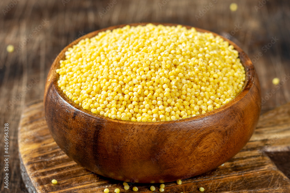 Millet. Millet in a wooden spoon and bowl on a wooden kitchen table