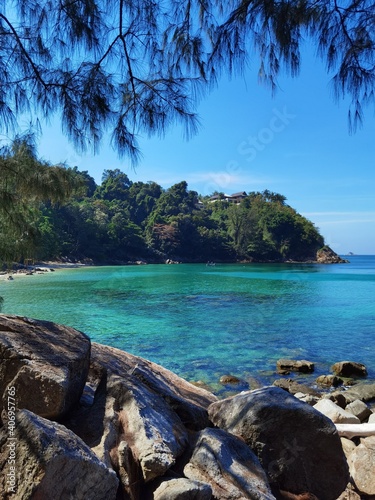 Green and blue water in lagoon around mountains and green trees