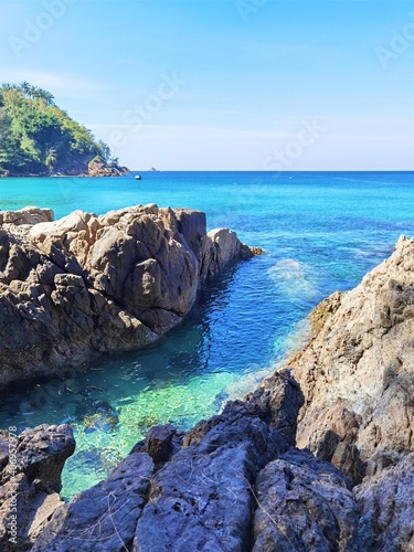 Green and blue water in lagoon around the cliff.