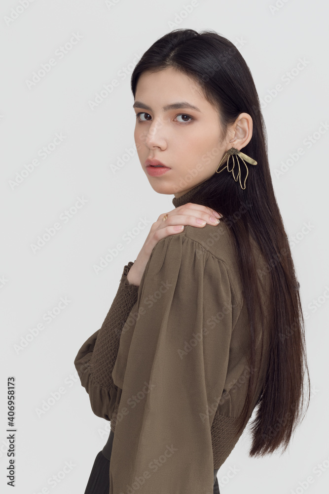 Beautiful asian girl with long hair and clean skin on a gray background Beautiful asian girl with long hair and clean skin on a gray background