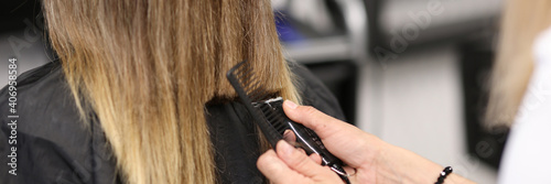 Woman holds hair clipper in her hands. New image of woman hairstyle concept.