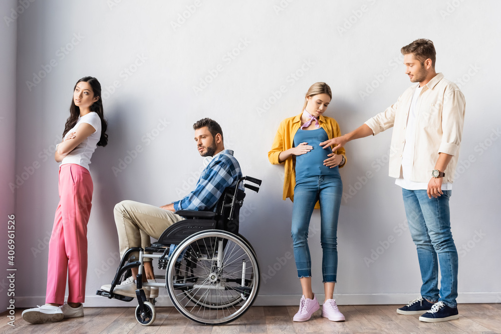 Multicultural people, pregnant woman and disabled man in wheelchair waiting in hall Multicultural people, pregnant woman and disabled man in wheelchair waiting in hall