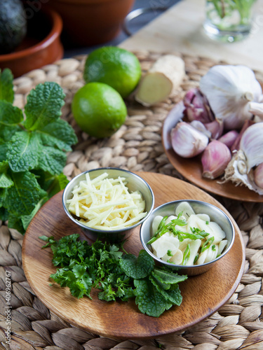 Sliced garlic and ginger with healthy herbs - coriander, mint and lime - healthy diet ingredients with Asian inspiration.