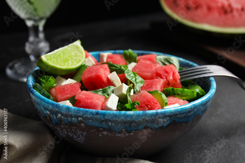 Delicious salad with watermelon served on black table, closeup