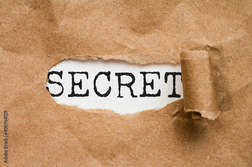 Secret.  the word secret appears in a hole in a folder photo