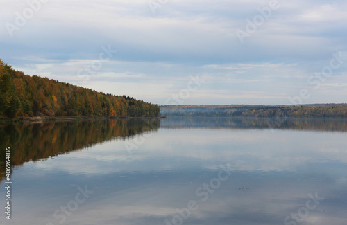the autumn forest is reflected in the lake