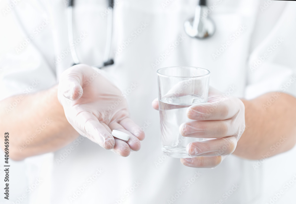 Painkiller and glass of water in doctor's hands Painkiller and glass of water in doctor's hands
