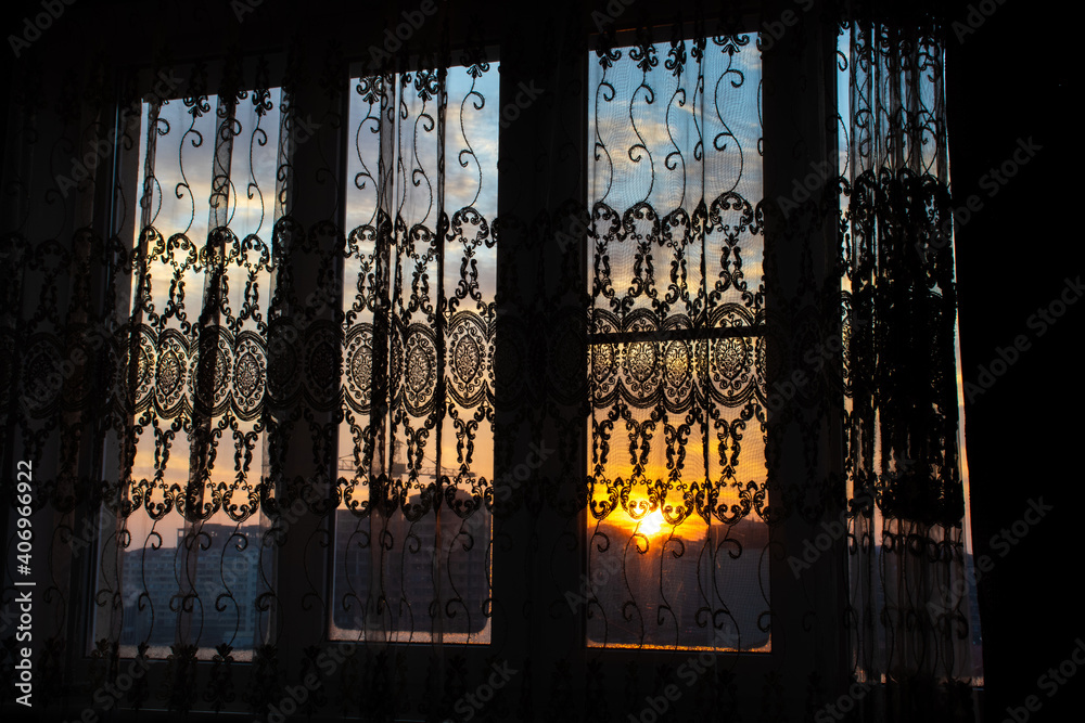 Sun shining through curtain. Sunrise through the window. The morning rays of the sun fall on the window