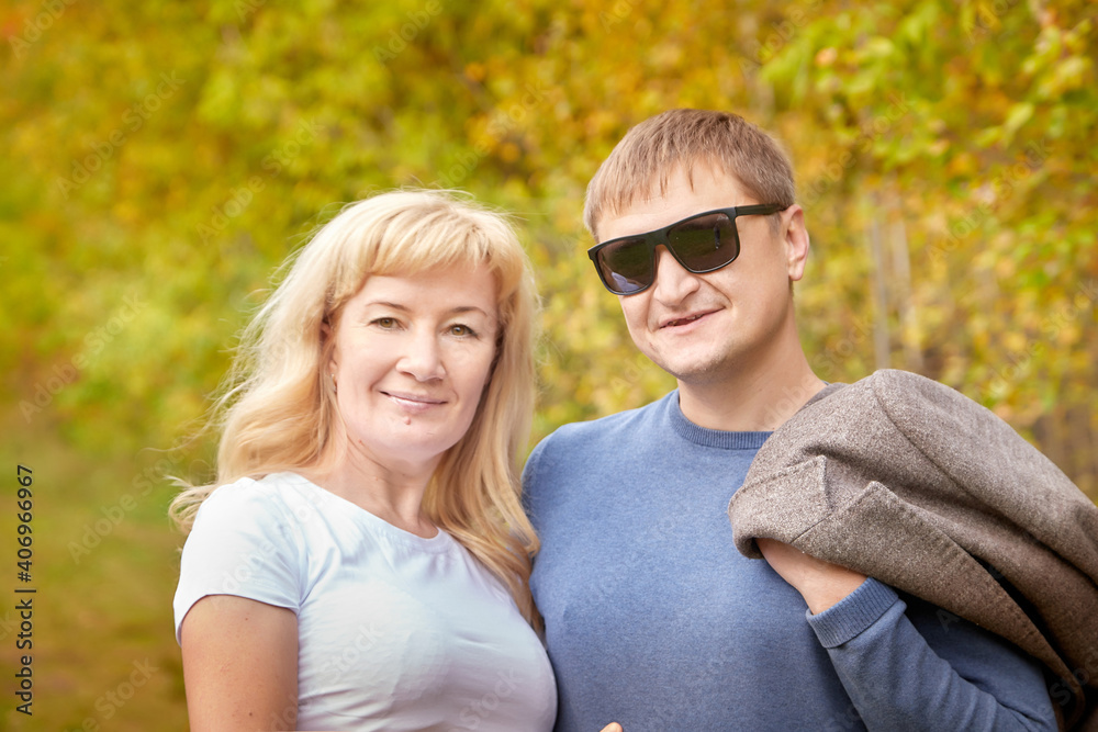 Fototapeta premium Middle-aged couple walking in the park on an autumn day.
