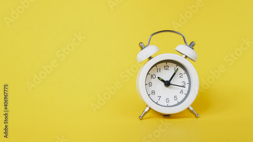 white analog white clock on vivid yellow background for time passing , appointment ,schedule, time out or planning concept