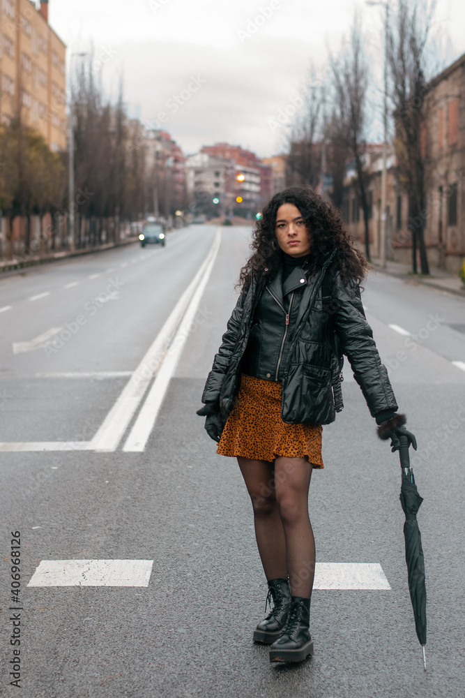 Fototapeta premium Chica posando en la carretera con paraguas