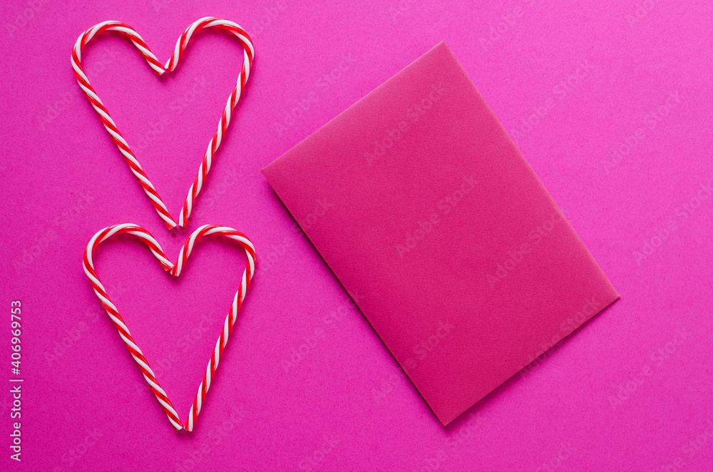 Festive pink background. Hearts of sweet candies with envelope. Love. Valentine's Day. 14 of February. Flat lay, top view.