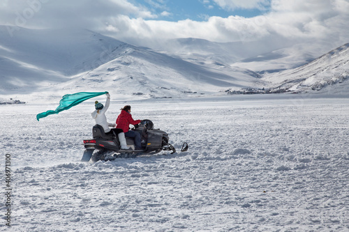 People on the snow sled on the frozen Cildir Lake (Cildir Golu) in Ardahan nearby Kars, Turkey