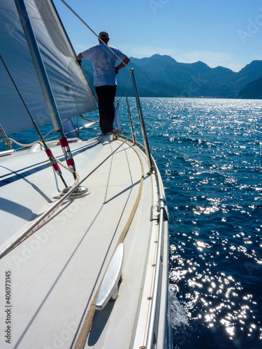 sail boat yacht in race regatta with sailor crew man with mountain background