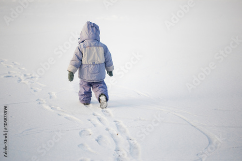 little lonely boy in winter on ice in the snow