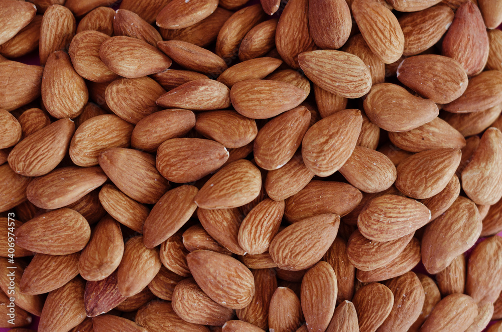 Background of almond close up, concept of vegetarianism and healthy lifestyle. Raw food. Flat lay. Top view. Background of almond close up, concept of vegetarianism and healthy lifestyle. Raw food. Flat lay. Top view.