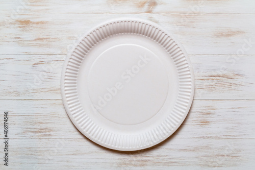 Disposable paper plate on wood background, eco-friendly