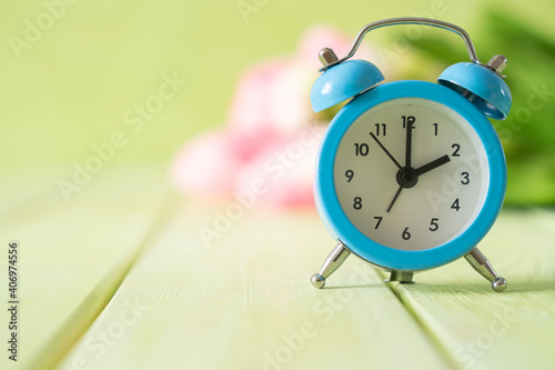Photography Spring time daylight saving concept - with alarm clock and flowers, copy space