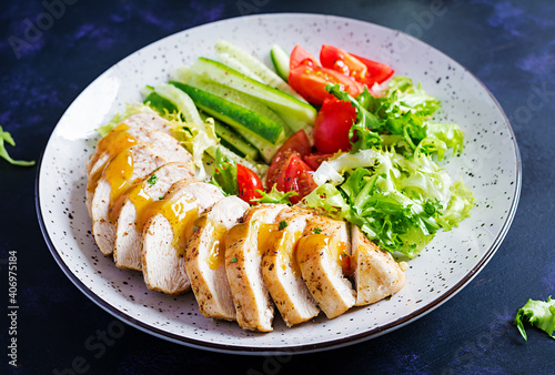 Ketogenic, keto food. Fried chicken fillet and fresh vegetable salad of tomatoes, cucumbers and lettuce. Chicken meat with salad. Healthy food.