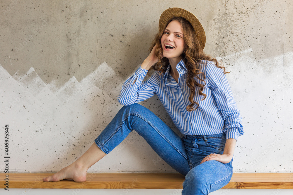 portrait of young pretty woman with straw hat jeans blue cotton shirt