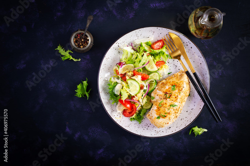 Ketogenic, keto food. Fried chicken fillet and fresh vegetable salad of tomatoes, cucumbers and lettuce. Chicken meat with salad. Healthy food. Top view, flat lay, copy space