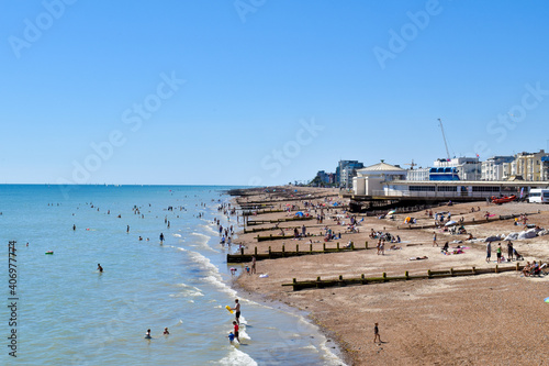 View of Worthing Beach UK, with people swimming in Summer