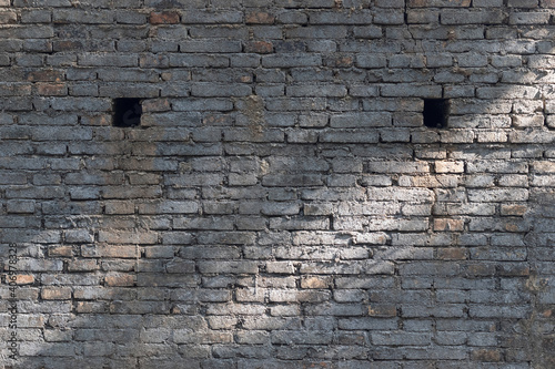 front view of brick gray cement wall with shadow from sunlight