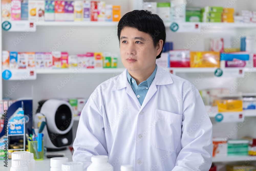 Portrait of men pharmacist asian standing Service in drugstore Thailand .