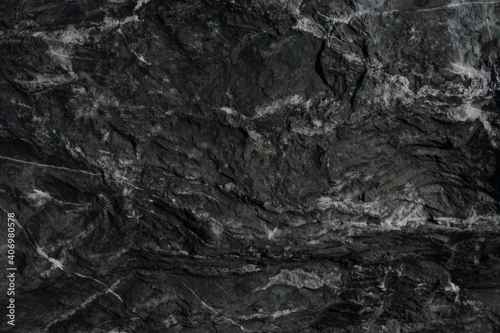 Black rough stone wall texture for background or wallpaper.
