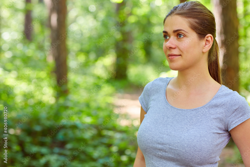 Portrait of woman standing in forest and looking away. Portrait of woman standing in forest and looking away.