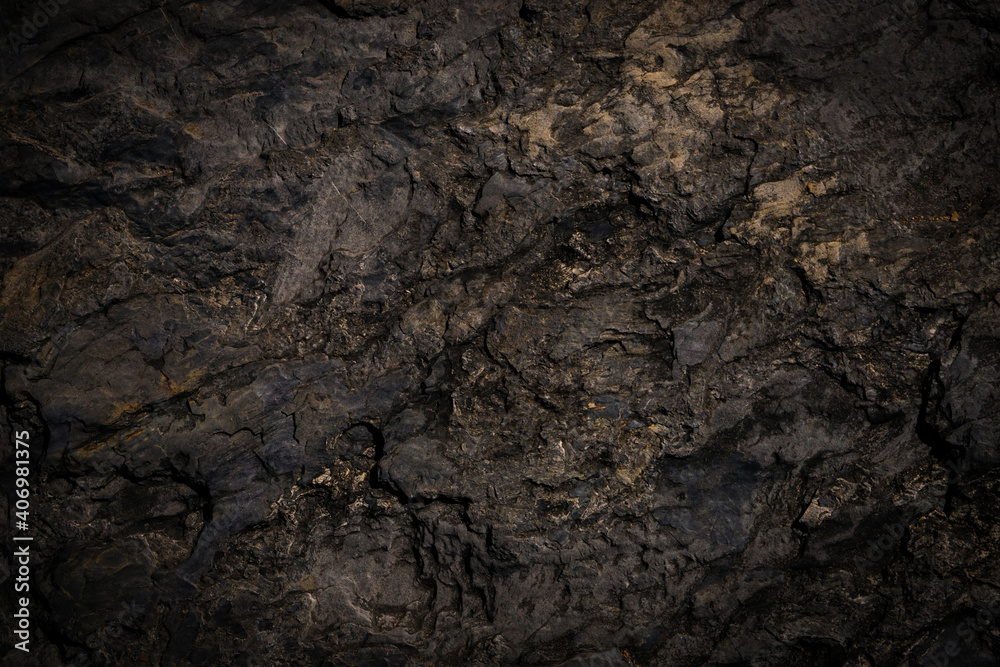 Rough cave stone wall surface with natural cracks used for background.