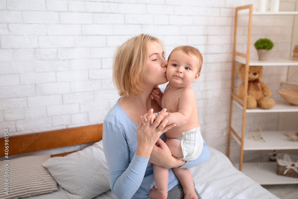 Blonde mother kissing her adorable little kid Blonde mother kissing her adorable little kid