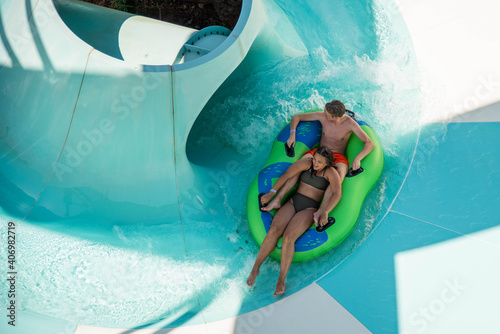 Girl and boy in water Park. Fun on the water. Teen girl and boy having fun in the water slider . Happy children's vacation outdoor.