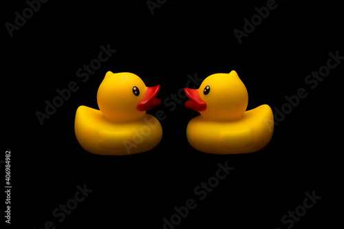 Two yellow rubber ducks facing each other photo