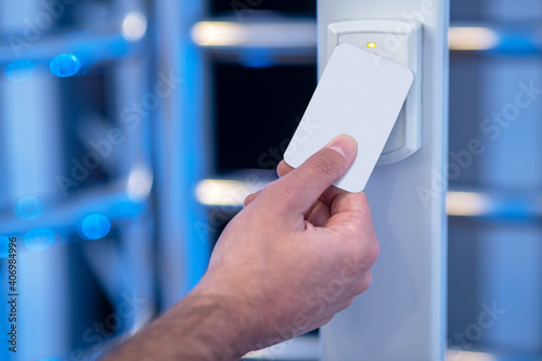 Male hand applying electronic badge to scanning device photo